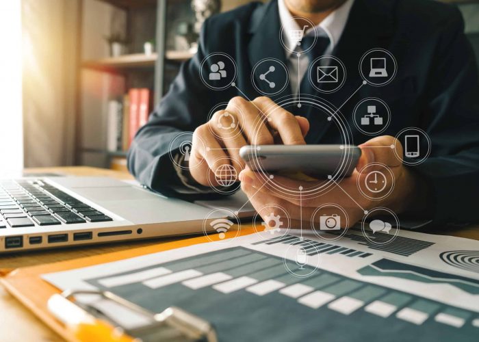 close up of businessman working with smart phone and laptop and digital tablet computer in modern office with virtual icon diagram